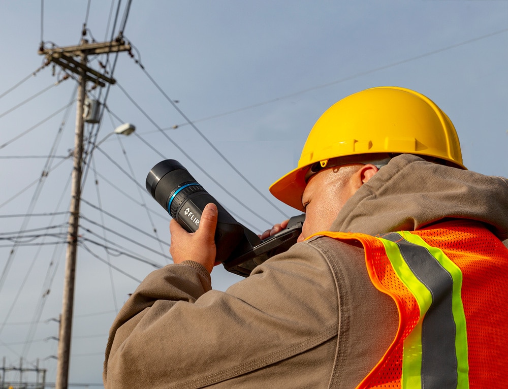 A man holding a FLIR T840 infrared camera.
